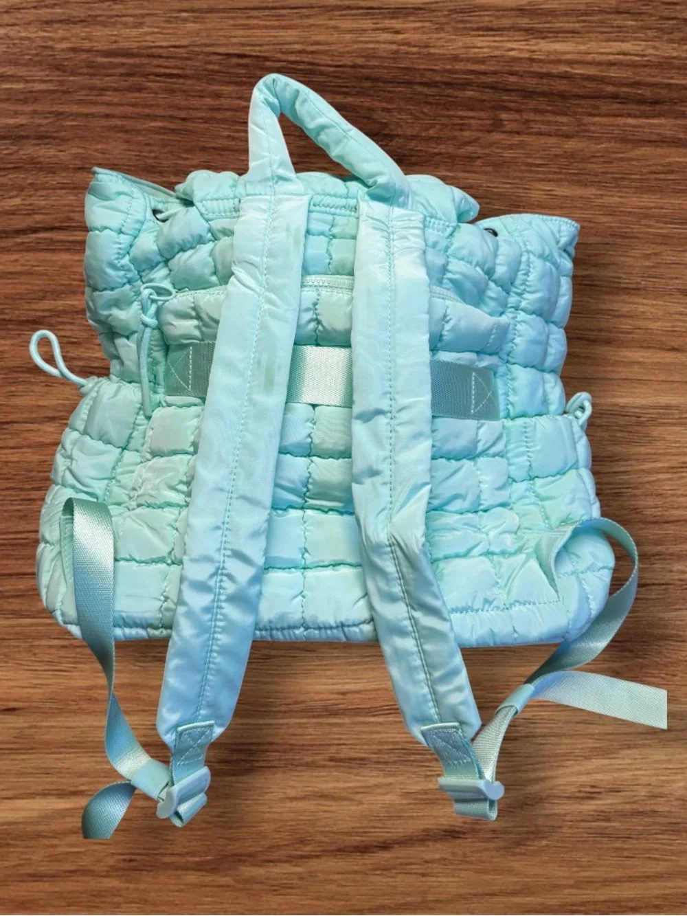 Iris Puff Backpack by Iris & Rainbow features a mint green quilted puffer design